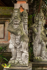 Traditional demon guards statue carved in stone in Bali.