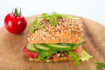 Körnerbrötchen mit Schinken, Gurken und Rucola.