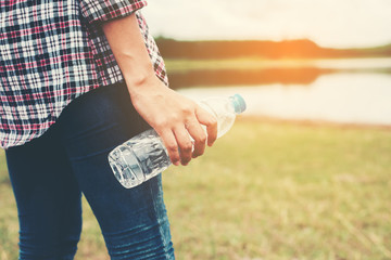 Fototapeta na wymiar young hipster woman holding bottle of water at summer green park