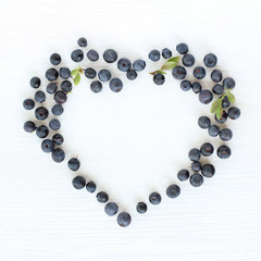 idea favorite berry dessert/ flat lay of the heart symbol wild blueberries top view 