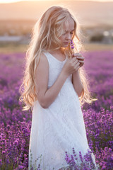 Beautiful small blond girl on the lavender field