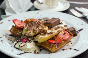 Belgian waffles with ice cream, chocolate and strawberries