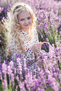 Beautiful small blond girl on the lavender field