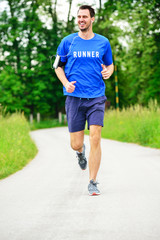 Fototapeta na wymiar Athletic young man running in the nature. Healthy lifestyle