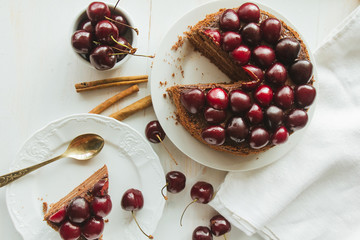 Chocolate layer cake with black cherry on white dish top view