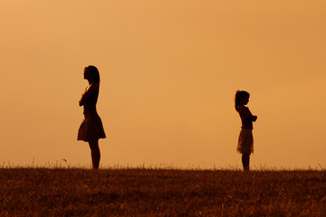 Silhouette of a angry mother and daughter on each other.