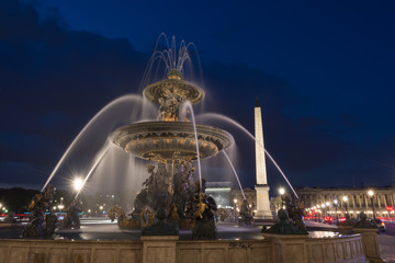 Obelisk of Luxor and fountain with water motion  at the Place de la Concorde in Paris at night