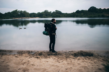 Backpacker standing at dune lake