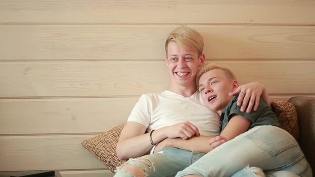 homosexuality, same-sex marriage concept - happy male gay couple hugging at home