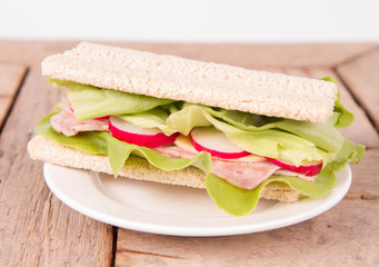 Crispbread sandwich with headcheese, cheese, radish and lettuce
