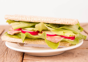 Crispbread sandwich with headcheese, cheese, radish and lettuce