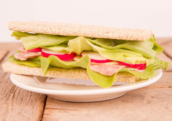 Crispbread sandwich with headcheese, cheese, radish and lettuce