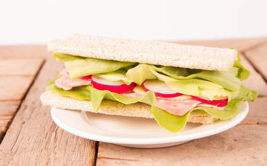 Crispbread sandwich with headcheese, cheese, radish and lettuce