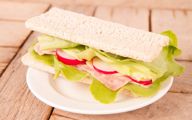 Crispbread sandwich with headcheese, cheese, radish and lettuce