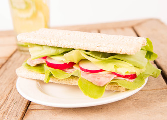 Crispbread sandwich with headcheese, cheese, radish and lettuce