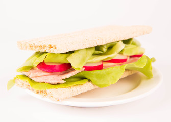 Crispbread sandwich with headcheese, cheese, radish and lettuce and a glass of lemonade
