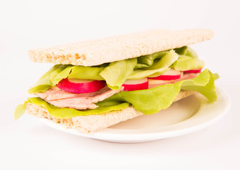 Crispbread sandwich with headcheese, cheese, radish and lettuce on a white background