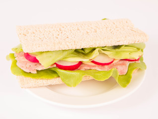 Crispbread sandwich with headcheese, cheese, radish and lettuce on a white background