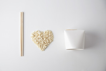 Top view I love wok takeaway noodles presentation with chopsticks, blank box and dry pasta isolated on white