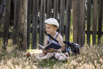 boy reads a book in a village on the nature