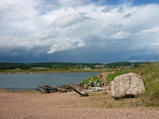 Landschaft mit Baggersee zur Gewinnung von Waschkies mit Regenwolken bei Sonnenschein in Kirchheim...