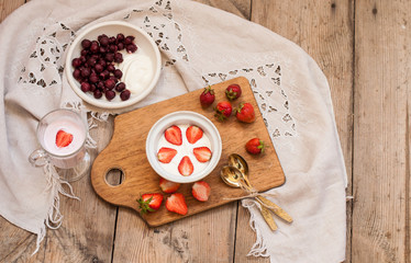 berry and strawberry dessert, rural vitamin breakfast, on a wooden background