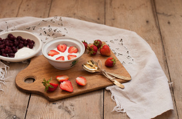 berry and strawberry dessert, rural vitamin breakfast, on a wooden background