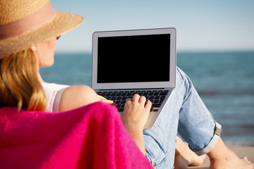 Woman with laptop on the beach