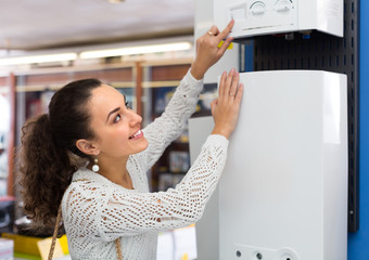 Woman buying heating water boiler.