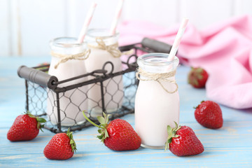 Strawberry yogurt in bottle on wooden table