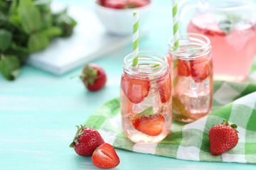 Fresh strawberry drink in bottle on wooden table