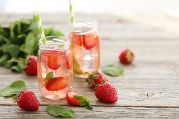 Fresh strawberry drink in bottle on wooden table