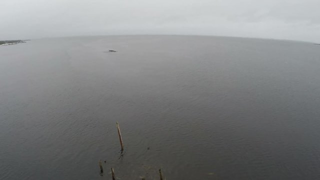 Aerial shot of old unfinished construction of the bridge in the White sea, by the mainland of Solovetsky islands