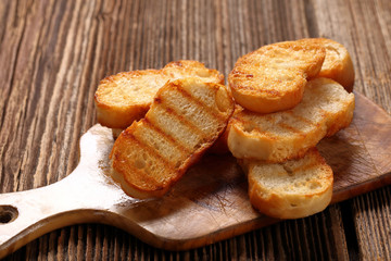 Grilled toasts on old wooden background