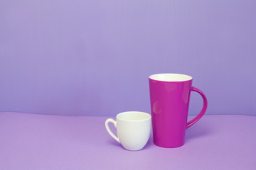 mug and coffee cup on a lilac background