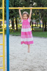 Fototapeta premium Girl hanging on a horizontal bar