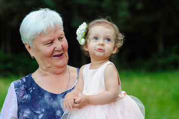 Grandmother and granddaughter walk in the park