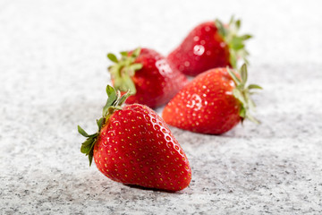 Four juicy strawberry on granite background