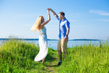 portrait of beautiful couple in love dancing on seacoast