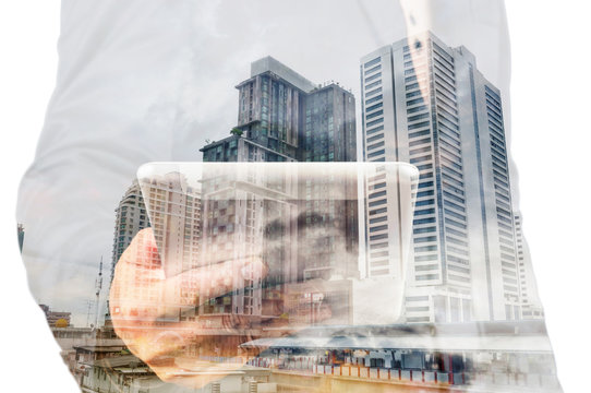 Double exposure of a businessman and a city using a tablet over