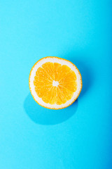 Juicy orange slice on blue background