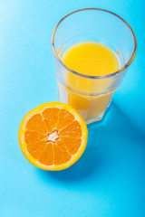 Glass of orange juice and half of orange