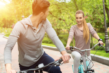 Fototapeta na wymiar Cute man and woman cycling in park