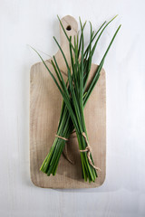 Fresh green chives on cutting board