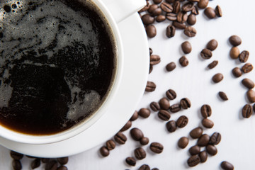 White cup with coffee and coffee seed on the table