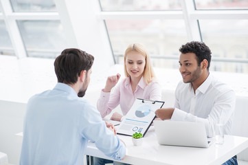 Young coworkers having brainstorming session in modern office