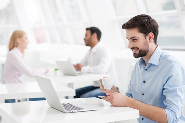 Businessman drinking coffee while working