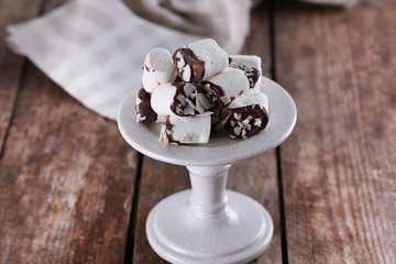 Tasty marshmallows with chocolate on plate, close up