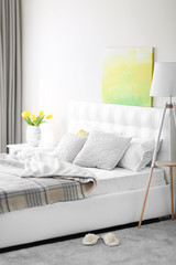 Bedroom interior in light tones with white furniture and pictures on the wall