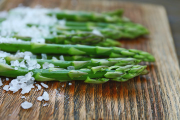 Asparagus with sea salt on cutting board